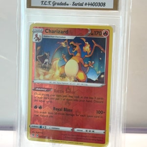May include: A graded Charizard Reverse Holo Pokémon card from the Vivid Voltage set. The card is encased in a protective holder and has a GEM MINT 10 grade. The card features a fiery Charizard illustration and the text "Charizard".
