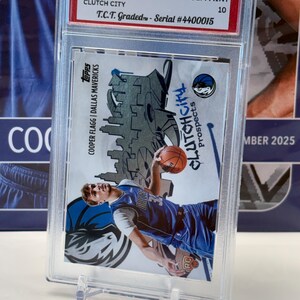 May include: A 2025 Topps NBA trading card featuring Cooper Flagg of the Dallas Mavericks, graded GEM MINT 10. The card is in a protective case and has the text "Clutch City Prospects".