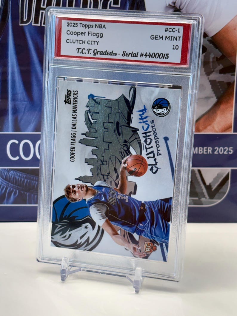 May include: A 2025 Topps NBA trading card featuring Cooper Flagg of the Dallas Mavericks, graded GEM MINT 10. The card is in a protective case and has the text "Clutch City Prospects".