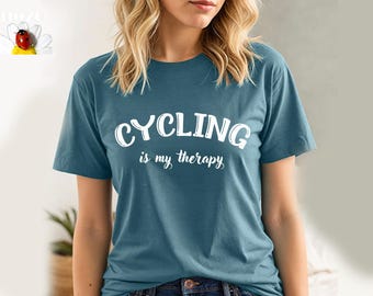 May include: A teal blue t-shirt with the text "CYCLING is my therapy" in white lettering.