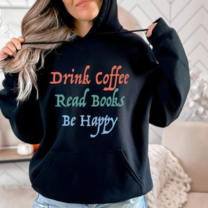 May include: Black hooded sweatshirt with the text "Drink Coffee Read Books Be Happy" in colourful lettering.