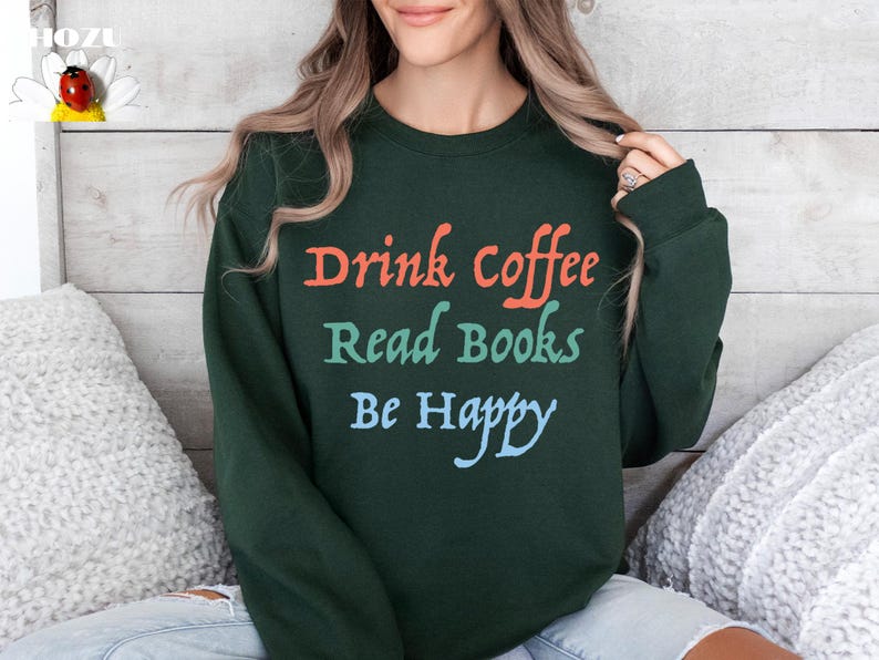 May include: A dark green sweatshirt with the text "Drink coffee Read Books Be Happy" in colourful lettering.