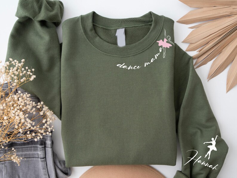 May include: A green sweatshirt with the text "dance mama" and a small ballerina graphic on the front. The right sleeve has the name "Hannah" written on it.