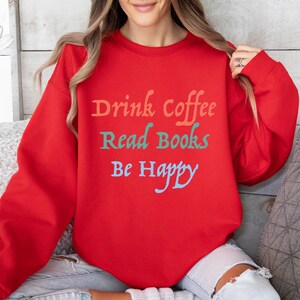 May include: Red sweatshirt with the text "Drink Coffee Read Books Be Happy" in colourful lettering.