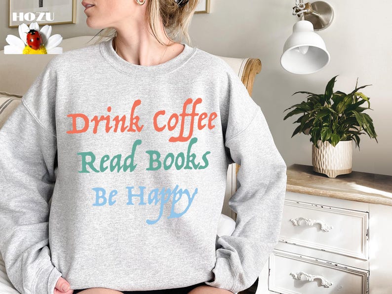 May include: Grey sweatshirt with the text "Drink coffee, Read books, Be Happy" in colourful lettering.