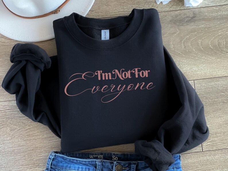 May include: Black sweatshirt with a rose gold graphic that says "I'm Not For Everyone".