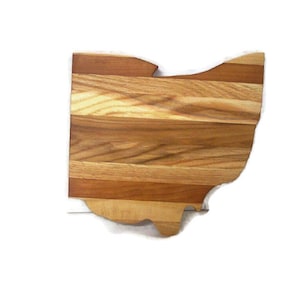 May include: A wooden cutting board shaped like the state of Ohio. The board is made of multiple wood types, creating a striped pattern.