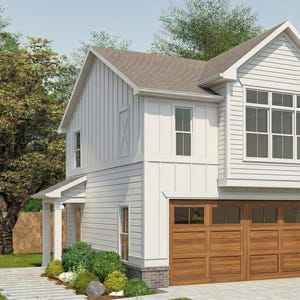 May include: A two-story white house with a brown roof and a two-car garage. The garage doors are made of wood. The house has multiple windows and is surrounded by trees and greenery. A stone walkway leads to the house.