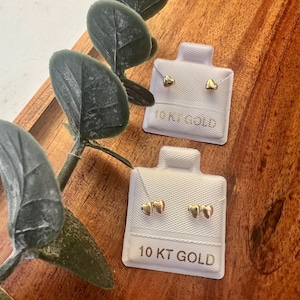 May include: A white ceramic mug with a black handle and the text "But First, Coffee" in a handwritten style. The mug is on a white surface. The mug is approximately 4 inches tall.