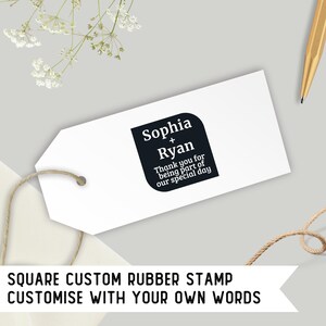 Puede incluir: Una etiqueta blanca con un sello de goma cuadrado negro que dice "Sophia + Ryan Gracias por ser parte de nuestro día especial". La etiqueta está atada con un cordel y está sobre un fondo gris. El texto "SQUARE CUSTOM RUBBER STAMP CUSTOMISE WITH YOUR OWN WORDS" está en la parte inferior de la imagen.