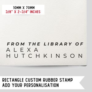 Pode incluir: Um carimbo de borracha personalizado em preto e branco com o texto "FROM THE LIBRARY OF ALEXA HUTCHKINSON". O carimbo é retangular e mede 10 mm por 70 mm.