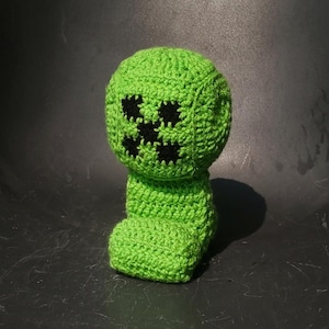 Peut inclure: Peluche en crochet vert en forme de Creeper de Minecraft. Le jouet a un visage noir avec un motif de visage de Creeper.