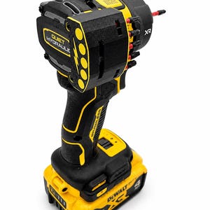 May include: A black and yellow cordless impact wrench with the text "QUIET HYDRAULIC" and "BRUSHLESS". The tool has a yellow battery pack with the text "DEWALT" and "20V".