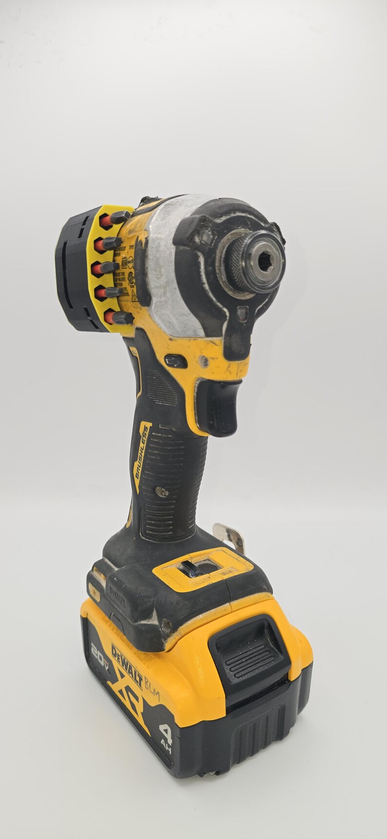 May include: A yellow and black cordless impact driver with a black handle and a yellow battery pack. The tool has the brand name "DEWALT" and "20V" printed on it.