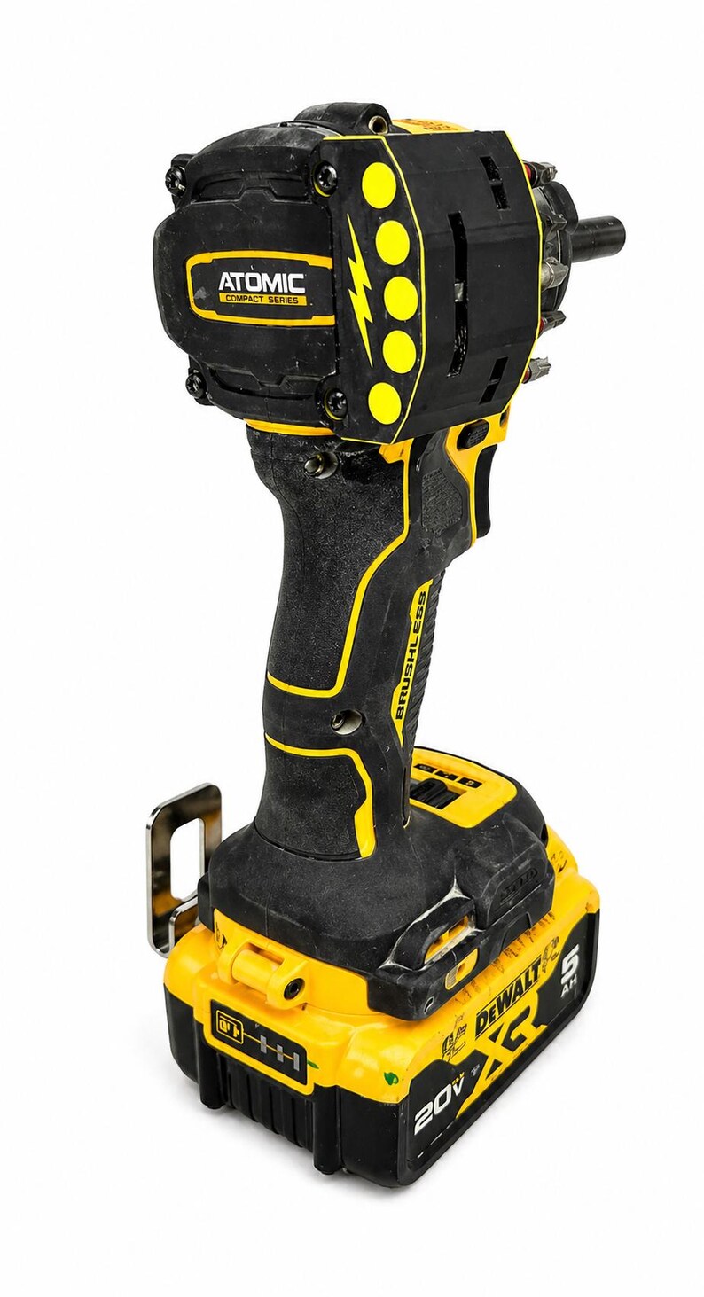 May include: Black and yellow cordless impact driver with the text "ATOMIC COMPACT SERIES" and "BRUSHLESS". The tool has a battery pack that reads "DEWALT 20V".