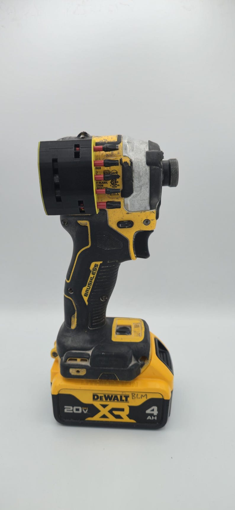 May include: A yellow and black DeWalt impact driver with a black battery pack. The tool has the word "BRUSHLESS" printed on the handle. The battery pack reads "20V" and "4 AH".