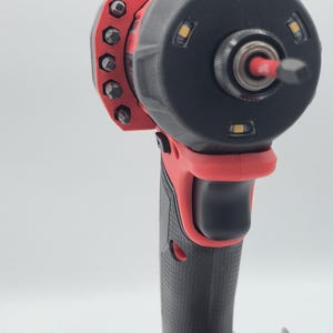 May include: A red and black cordless impact driver with a black head and a variety of bits. The tool has a textured grip and three LED lights around the head.