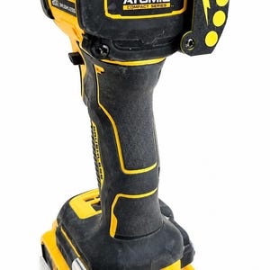 May include: A black and yellow DeWalt Atomic Compact Series 20V brushless impact driver. The tool has a black handle with yellow accents, a yellow battery base, and a black head with the Atomic logo and a lightning bolt design.