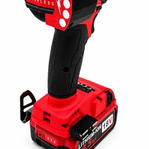 Puede incluir: Taladro inal&aacute;mbrico rojo y negro con el texto "FUEL BRUSHLESS" y "LITHIUM-ION 18V 6.5AH". El taladro tiene un mango negro y una bater&iacute;a roja.