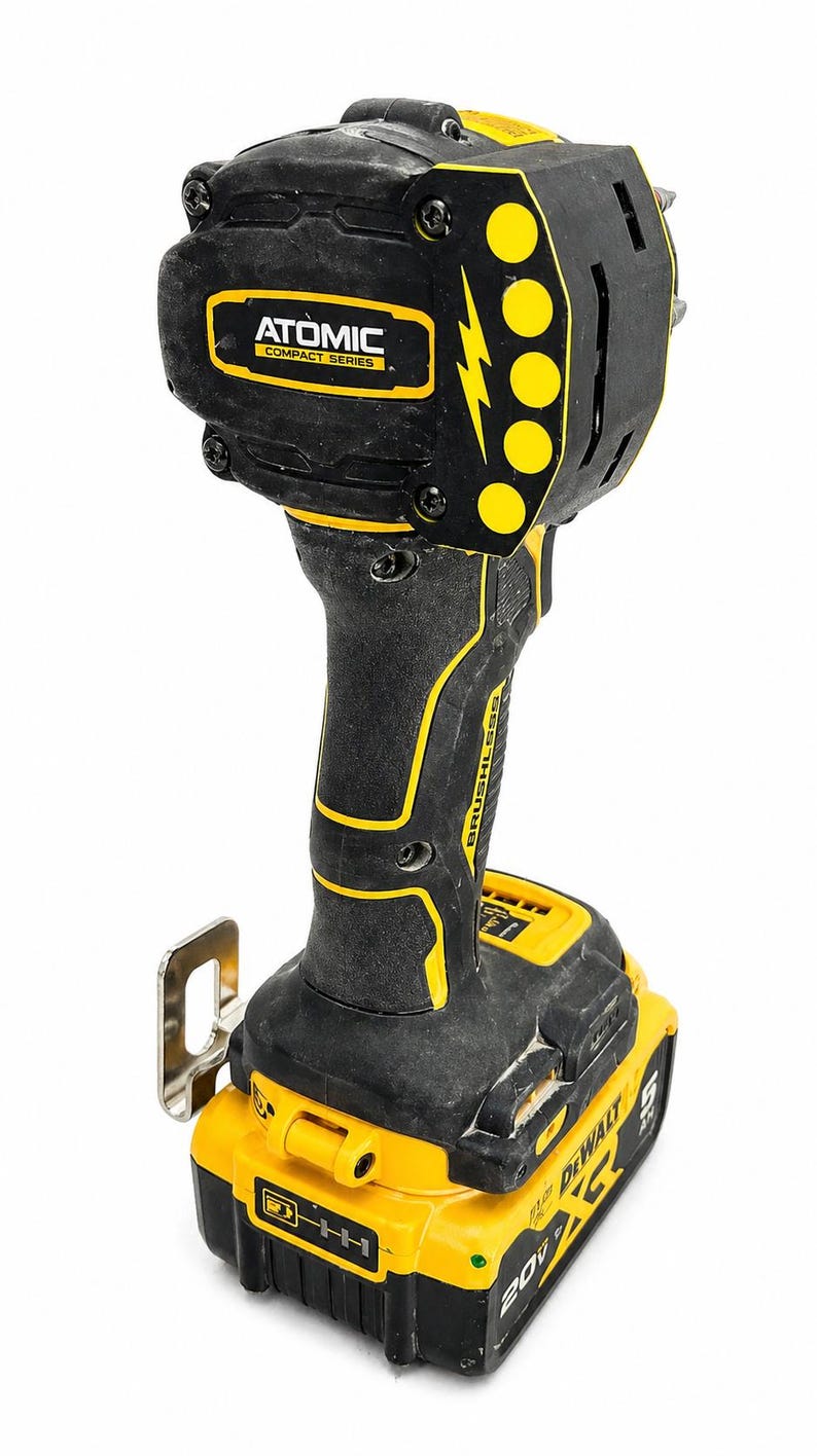 May include: Black and yellow cordless impact driver with the text "ATOMIC COMPACT SERIES" and "BRUSHLESS". The tool has a battery pack that reads "DEWALT 20V".