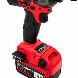 Puede incluir: Atornillador de impacto inal&aacute;mbrico rojo y negro con mango negro y bater&iacute;a roja. La bater&iacute;a est&aacute; etiquetada como "LITHIUM-ION 6.5AH 18V". La herramienta tiene un portabrocas negro y una punta roja.