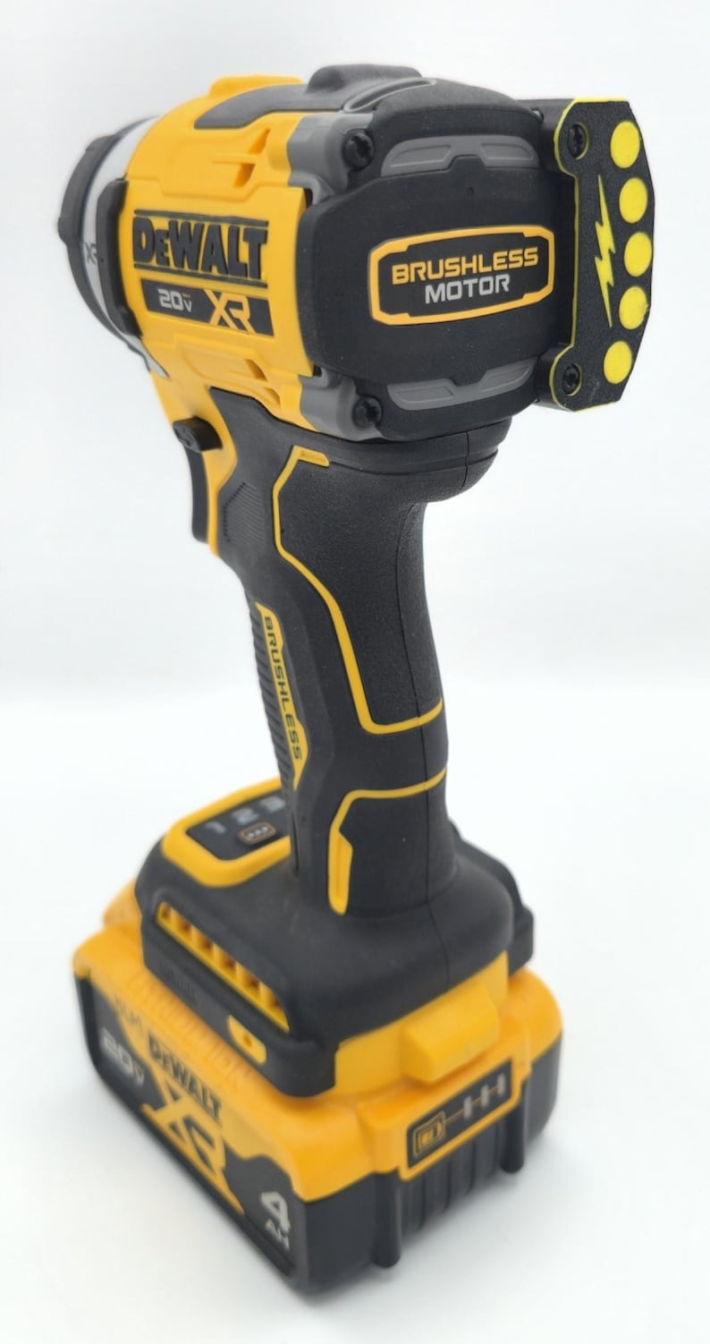 May include: A yellow and black DeWalt 20V XR brushless motor impact driver. The tool has a black handle with yellow accents and a yellow battery pack. The text "DEWALT" and "BRUSHLESS MOTOR" are visible on the tool.