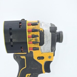 May include: A yellow and black cordless impact driver with a black head. The tool has a silver metal body and a black handle. The impact driver has the text "Reduce the risk of injury" printed on it.