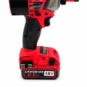 Puede incluir: Un atornillador de impacto inal&aacute;mbrico rojo y negro con un mango negro y una bater&iacute;a. La bater&iacute;a est&aacute; etiquetada como "LITHIUM-ION 6.5AH 18V". La herramienta tiene una parte delantera de pl&aacute;stico transparente y una parte superior negra.