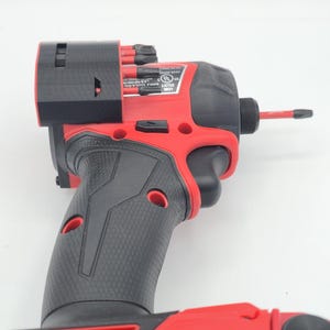 May include: A red and black cordless impact driver with a black grip. The tool has a black head and a red battery pack. The battery pack reads "LITHIUM-ION 6.5AH 18V".