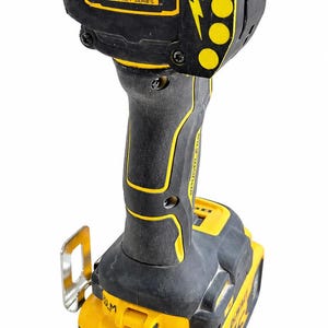 May include: A black and yellow Atomic Compact Series impact driver. The tool has a black handle with yellow accents and a yellow battery pack. The head of the tool has the text "ATOMIC COMPACT SERIES" in a yellow rectangle.