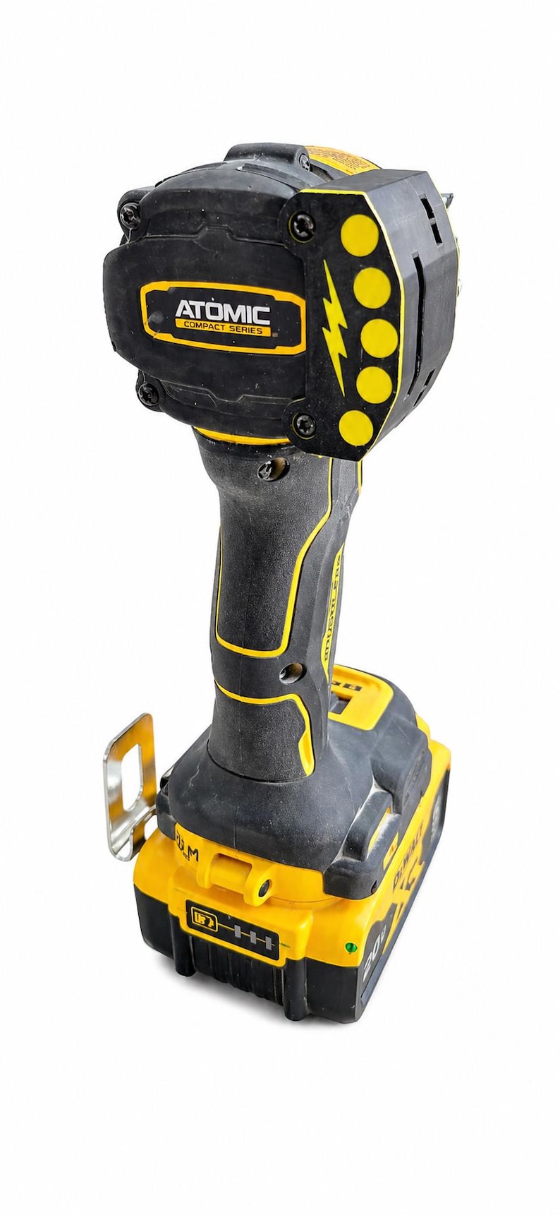 May include: A black and yellow Atomic Compact Series impact driver. The tool has a black handle with yellow accents and a yellow battery pack. The head of the tool has the text "ATOMIC COMPACT SERIES" in a yellow rectangle.