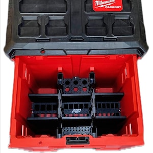 Puede incluir: Una caja de herramientas Milwaukee Packout roja y negra con múltiples compartimentos. La parte superior es negra con varias áreas de almacenamiento rectangulares. El interior es rojo con divisores negros y el texto "8420". El logotipo de Milwaukee es visible.