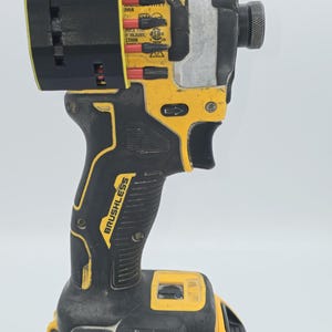 May include: A yellow and black DeWalt 20V XR brushless impact driver. The tool has a black handle with the word "Brushless" printed on it. The battery is yellow and black and reads "20V MAX" and "4 AH".