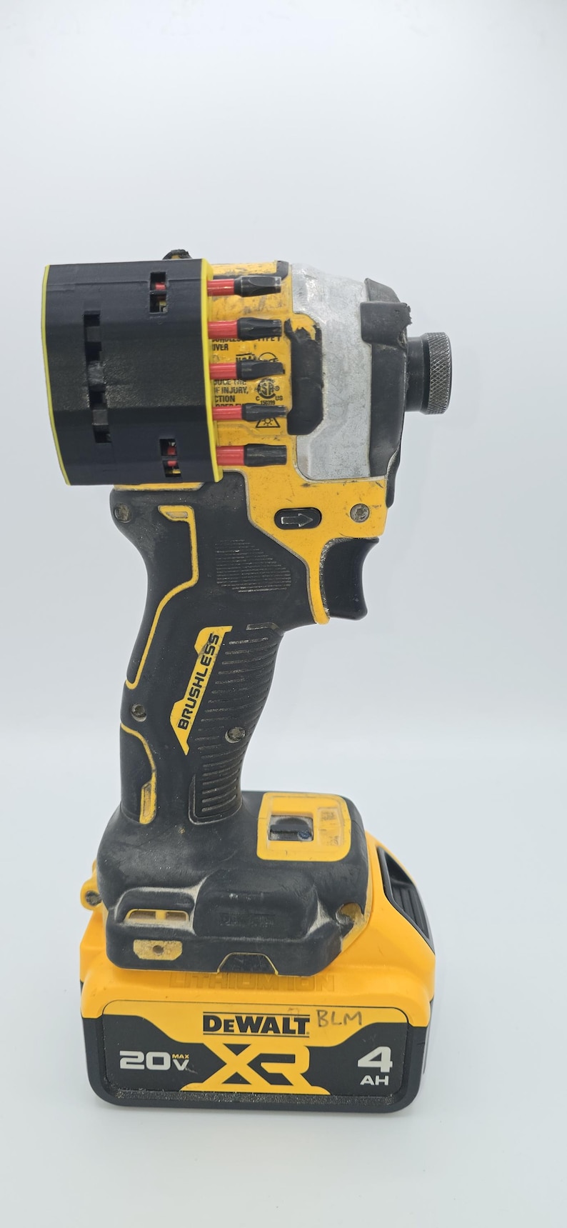 May include: A yellow and black DeWalt 20V XR brushless impact driver. The tool has a black handle with the word "Brushless" printed on it. The battery is yellow and black and reads "20V MAX" and "4 AH".