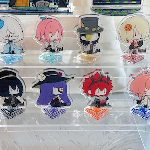 Puede incluir: Un conjunto de ocho soportes de personajes de acrílico con personajes de estilo anime con cabello y ropa de diferentes colores. Los soportes se muestran en una estantería de acrílico transparente.