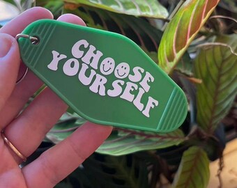 May include: Green motel key chain with the text "CHOOSE YOURSELF" in white, with two smiley faces in the text.