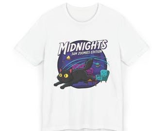 Pode incluir: Camiseta branca com um desenho animado. O desenho mostra um gato preto com olhos amarelos correndo por uma sala com móveis. O texto "MIDNIGHTS 3AM ZOOMIES EDITION" está acima do gato em uma fonte estilizada.