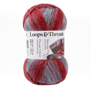 Op de afbeelding: Een bol Loops & Threads Skyscape acrylgaren in een gemêleerde kleur van dieprood en zacht blauwgrijs. Het witte label bevat de tekst Loops & Threads, Skyscape, Paysage Céleste en de specificaties 262 yd / 3.5 oz / 240 m / 100 g.
