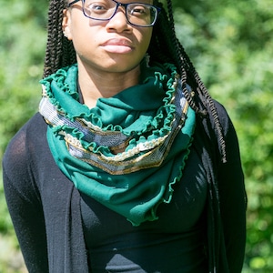 Model wears green scarf wrapped twice around neck. Emerald green infinity scarf with kelly green ruffled edges, lace and mustard yellow and green plaid trim. Scarf of vintage tube jersey knit fabric, vintage lace and vintage jersey knit plaid fabric.