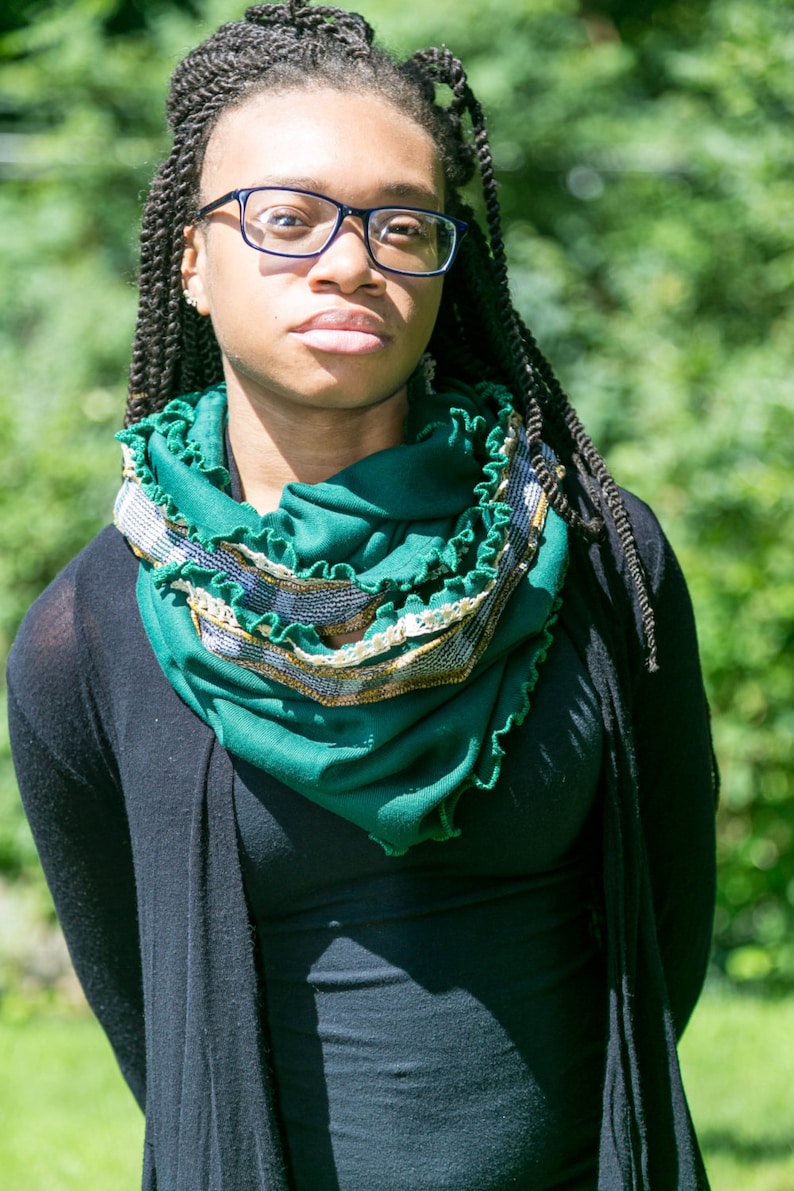 Model wears green scarf wrapped twice around neck. Emerald green infinity scarf with kelly green ruffled edges, lace and mustard yellow and green plaid trim. Scarf of vintage tube jersey knit fabric, vintage lace and vintage jersey knit plaid fabric.