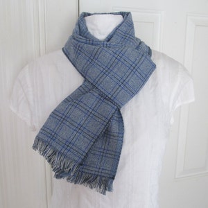 Blue and white plaid linen blend scarf with frayed fringe ends measures 74 inches long by 9 1/4 inches wide. Can be folded in half to form a loop, then slip ends through and wrap around your neck.