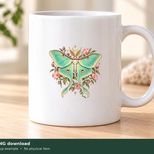 Pu&ograve; includere: Una tazza in ceramica bianca con una grafica centrale raffigurante una falena luna verde chiaro circondata da piccoli fiori rosa, foglie verdi e un simbolo di mezzaluna dorata posizionato sopra la testa della falena.