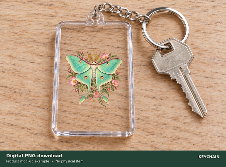 Pu&ograve; includere: Un portachiavi rettangolare in acrilico trasparente con un'illustrazione stampata di una falena luna verde chiaro circondata da piccoli fiori rosa e foglie verdi. Un anello e una catenella in metallo argentato sono fissati in alto.