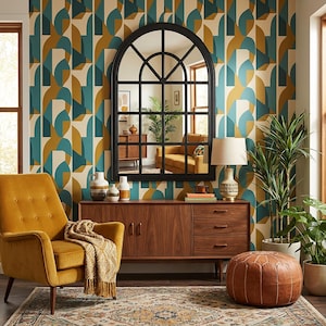 May include: A mid-century modern living room with a mustard yellow armchair, a wooden credenza, and a large black arched mirror. The room features a patterned wallpaper in teal, gold, and cream, with a leather ottoman and potted plants.
