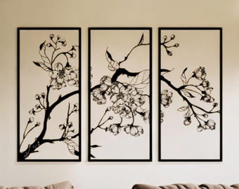 May include: A triptych of framed wall art featuring black and white floral branch designs. Each panel has a black frame and a cream-colored background. The artwork depicts blossoming branches with detailed leaves and flowers, creating a nature-inspired aesthetic.