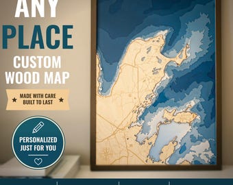 May include: A framed 3D layered wood map featuring a light tan landmass against deep blue water depths. The text reads ANY PLACE CUSTOM WOOD MAP, MADE WITH CARE BUILT TO LAST, and PERSONALIZED JUST FOR YOU. Icons indicate premium wood and 3D design.