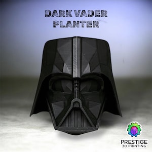 May include: A black Dark Vader planter, 3D printed in a geometric design. The planter is in the shape of Darth Vader's helmet, with the text "DARK VADER PLANTER" above it. The Prestige 3D Printing logo is in the bottom right corner.