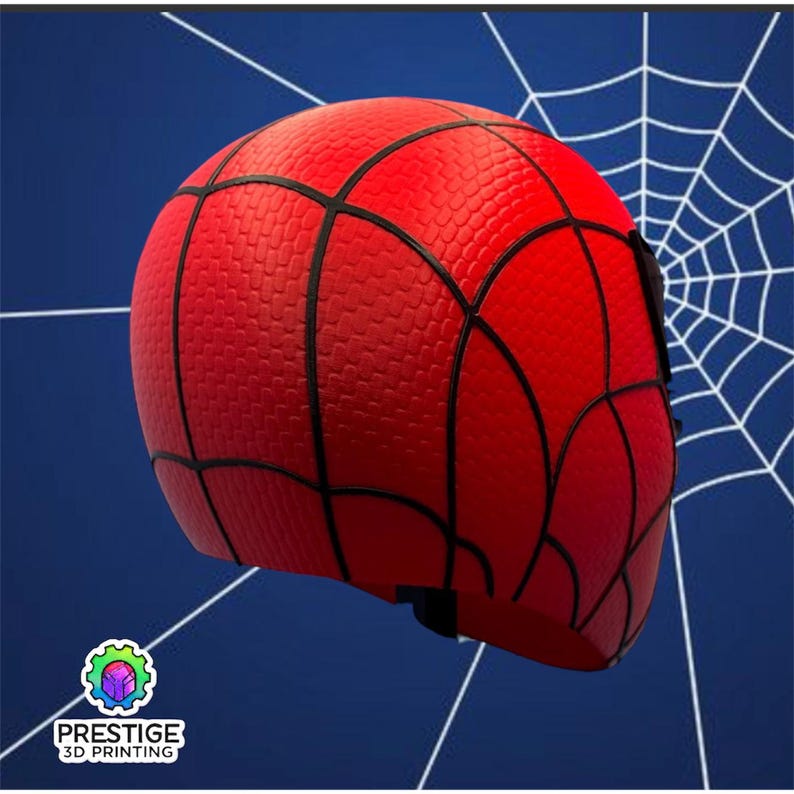 Puede incluir: Una m&aacute;scara de Spider-Man roja y negra con una superficie texturizada y un dise&ntilde;o de telara&ntilde;a. La m&aacute;scara cubre toda la cabeza, con l&iacute;neas negras que delinean el patr&oacute;n de la telara&ntilde;a. El fondo es azul con un dise&ntilde;o de telara&ntilde;a blanca.