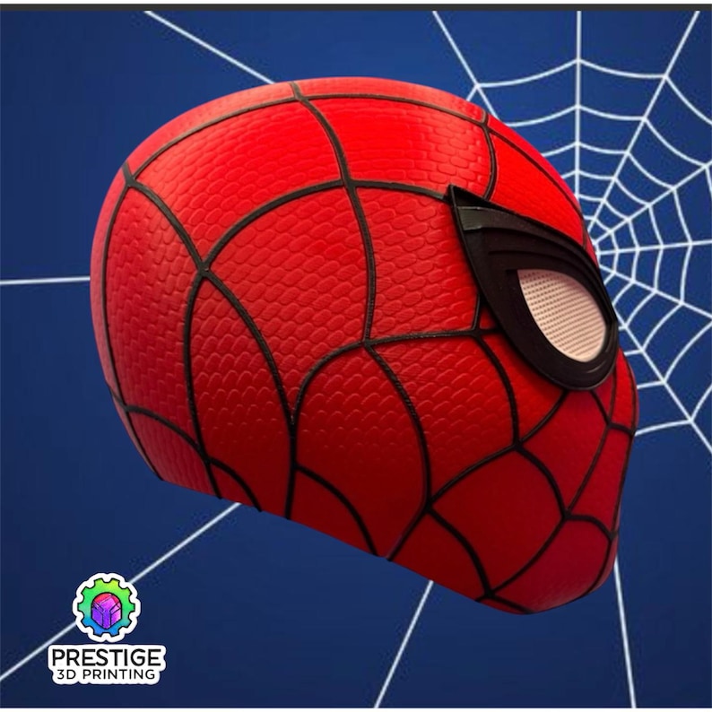 Puede incluir: Una m&aacute;scara de Spider-Man roja y negra con una superficie texturizada y detalles de telara&ntilde;a negros. La m&aacute;scara presenta cubiertas oculares negras con una malla blanca. El fondo es azul con un dise&ntilde;o de telara&ntilde;a blanca. El logotipo "PRESTIGE 3D PRINTING" est&aacute; en la esquina inferior izquierda.