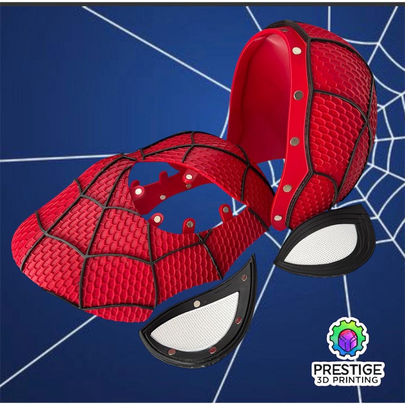 Puede incluir: Una m&aacute;scara de Spider-Man roja y negra, desmontada, con dos piezas para los ojos. La m&aacute;scara tiene un patr&oacute;n texturizado y detalles de telara&ntilde;a negros. El fondo es azul con un dise&ntilde;o de telara&ntilde;a blanca.